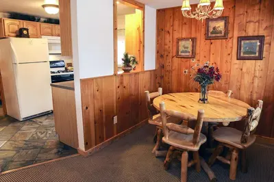 a kitchen with a wooden table and a refrigerator at Lazy R Cottages- 8 cabin in Estes Park