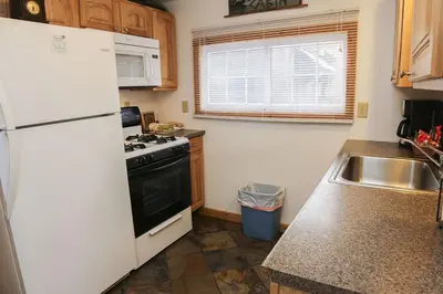 a kitchen with a white refrigerator and a sink at Lazy R Cottages- 8 cabin in Estes Park