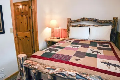 a bedroom with a bed with a quilt on it at Lazy R Cottages- 8 cabin in Estes Park