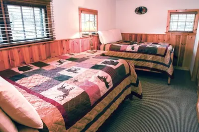 two beds in a room with a quilt at Lazy R Cottages- 8 cabin in Estes Park