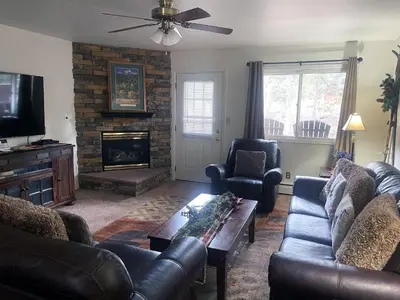 a living room with leather furniture and a fireplace at Fawn Valley Inn- 242 apts in Estes Park