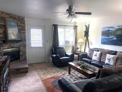 a living room with a couch and chairs and a fireplace at Fawn Valley Inn- 242 apts in Estes Park