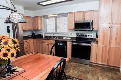 a kitchen with a wooden table and a black stove top oven at Fawn Valley Inn- 242 apts in Estes Park