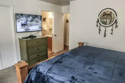 a bedroom with a large blue bed and a dresser at Fawn Valley Inn- 242 apts in Estes Park