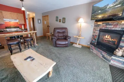 a living room with a fireplace and a television at Fawn Valley Inn- 306 apts in Estes Park