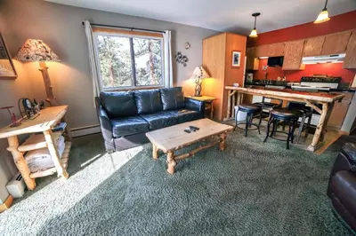a living room with a couch and a table at Fawn Valley Inn- 306 apts in Estes Park