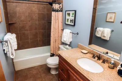 a bathroom with a sink and a toilet and a shower at Fawn Valley Inn- 306 apts in Estes Park