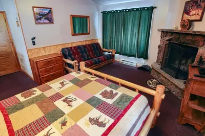 a room with a bed and a couch and a fireplace at Lazy R Cottages- 7B cottage in Estes Park