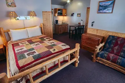 a bedroom with a bed and a couch and a chair at Lazy R Cottages- 7B cottage in Estes Park