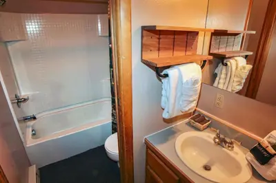 a bathroom with a sink and a toilet and a tub at Lazy R Cottages- 7B cottage in Estes Park