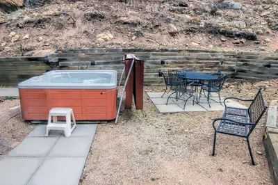 a patio with a hot tub and a table and chairs at Timber Creek Chalets- 8 chalet in Estes Park