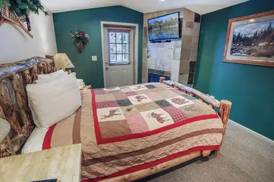 a bedroom with a bed and green walls at Fawn Valley Inn- 107 condo in Estes Park