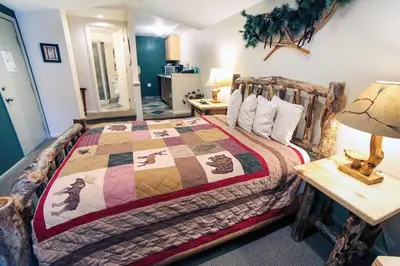 a bedroom with a bed with a quilt on it at Fawn Valley Inn- 107 condo in Estes Park