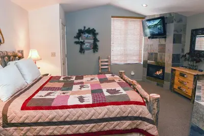 a bedroom with a bed with a quilt on it at Fawn Valley Inn- 103 condo in Estes Park