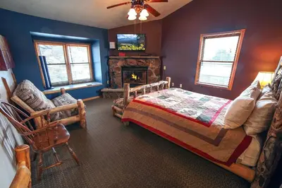 a bedroom with a bed and a fireplace at Lazy R Cottages- 18 cabin in Estes Park