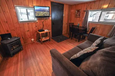 a living room with a couch and a stove at Triple R Cottages- 3 cabin in Estes Park