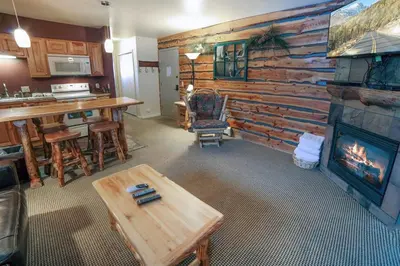 a living room with a fireplace and a table at Fawn Valley Inn- 300 condo in Estes Park