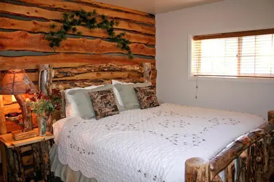 a bed in a room with a log wall at Fawn Valley Inn- 300 condo in Estes Park