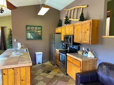 a kitchen with wooden cabinets and a counter top at Lazy R Cottages- 15 cabin in Estes Park