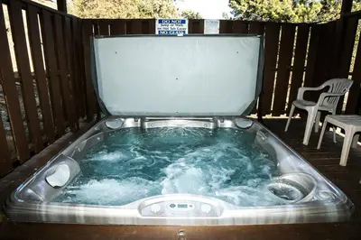 a hot tub on a deck with a table and chairs at Lazy R Cottages- 15 cabin in Estes Park