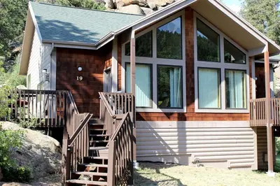 a house with a wooden staircase in front of it at Sunnyside Knoll- 19 apts in Estes Park