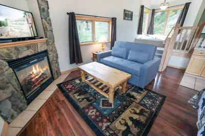 a living room with a blue couch and a fireplace at Sunnyside Knoll- 19 apts in Estes Park