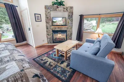 a living room with a couch and a fireplace at Sunnyside Knoll- 19 apts in Estes Park
