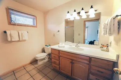 a bathroom with a sink and a toilet and a mirror at Sunnyside Knoll- 19 apts in Estes Park
