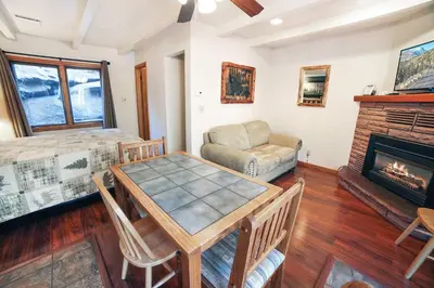 a living room with a table and a fireplace at Sunnyside Knoll- 11 apts in Estes Park