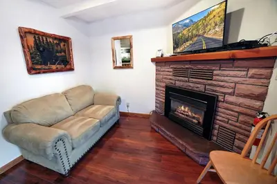 a living room with a couch and a fireplace at Sunnyside Knoll- 11 apts in Estes Park