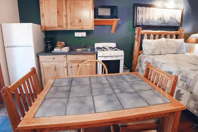 a kitchen with a wooden table and a kitchen with a refrigerator at Sunnyside Knoll- 11 apts in Estes Park