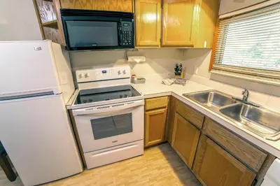a kitchen with a white stove top oven next to a sink at Sunnyside Knoll- 16 cabin in Estes Park