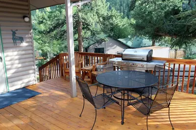 a patio with a table and a grill on a deck at Sunnyside Knoll- 16 cabin in Estes Park