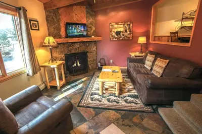 a living room with leather furniture and a fireplace at Sunnyside Knoll- 15 cabin in Estes Park