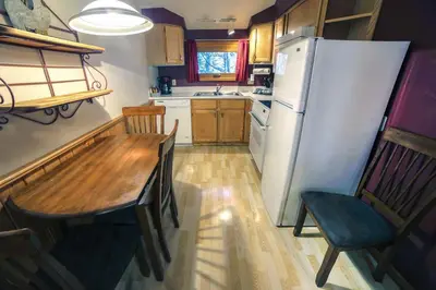 a kitchen with a wooden table and a refrigerator at Sunnyside Knoll- 15 cabin in Estes Park