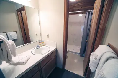 a bathroom with a sink and a shower with a mirror at Sunnyside Knoll- 15 cabin in Estes Park