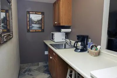 a kitchen with a sink and a microwave at Fawn Valley Inn- 102 condo in Estes Park