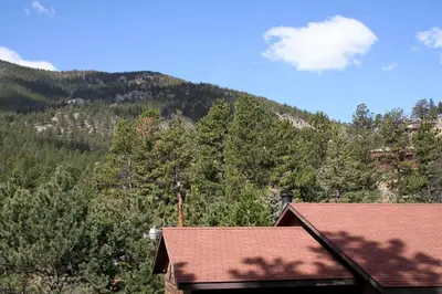 a view of a mountain with trees and a house at Timber Creek Chalets- 12 chalet in Estes Park