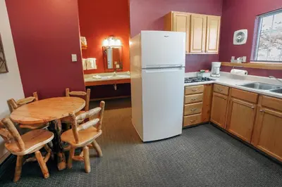 a kitchen with a table and a white refrigerator at Timber Creek Chalets- 12 chalet in Estes Park