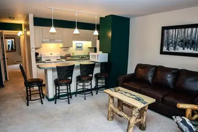 a living room with a couch and a table and a kitchen at Fawn Valley Inn- 282 condo in Estes Park