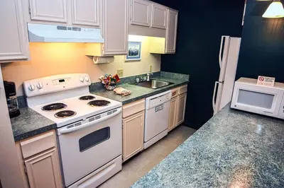 a small kitchen with white appliances and a sink at Fawn Valley Inn- 282 condo in Estes Park