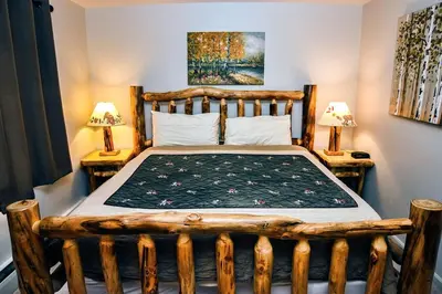 a bedroom with a wooden bed with two night stands at Fawn Valley Inn- 282 condo in Estes Park