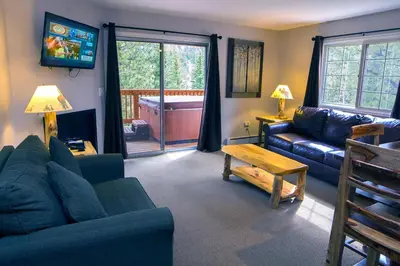 a living room with a couch and a tv at Fawn Valley Inn- 303 apts in Estes Park