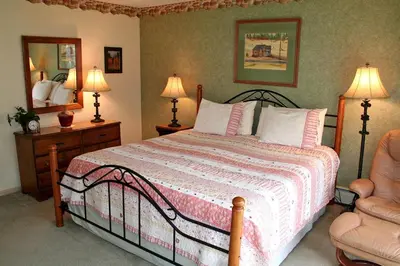a bedroom with a bed with two lamps and a chair at Fawn Valley Inn- 240 condo in Estes Park