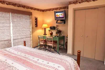 a bedroom with a bed and a table and a television at Fawn Valley Inn- 240 condo in Estes Park