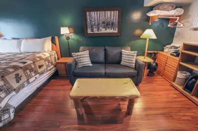 a bedroom with a bed and a couch and a coffee table at Sunnyside Knoll- 2 cottage in Estes Park