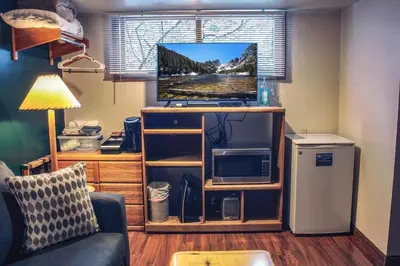 a living room with a tv and a couch at Sunnyside Knoll- 2 cottage in Estes Park