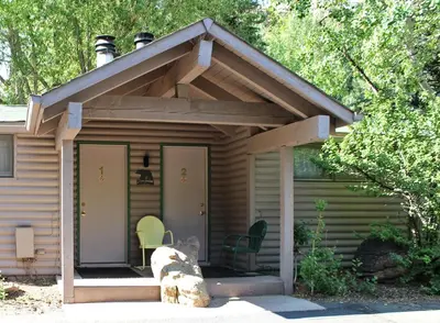 a small house with a pitched roof with a patio at Sunnyside Knoll- 2 cottage in Estes Park