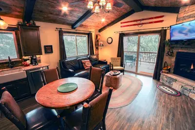 a living room with a table and a couch and a television at Fawn Valley Inn- 269 condo in Estes Park