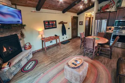 a living room with a fireplace and a table at Fawn Valley Inn- 269 condo in Estes Park